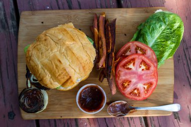 bir ev yapımı sos ve taze domates ve marul bir ahşap kesme tahtası üzerinde ızgara bitki esaslı burger hizmet