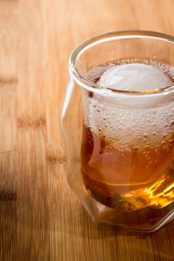 Bir ahşap bar üst alınarak bir buz küresi ile viski soda bir çift duvarlı viski bardağına servis servis