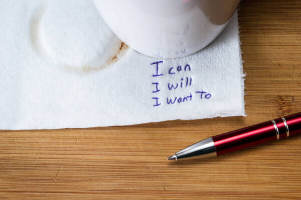 hand written note on a coffee stained napkin with an empowering message, I can I will I want to.