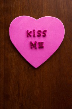 Öp beni bir ahşap dolap üzerinde sıkışmış bir pembe kalp glitter harflerle kelimeler