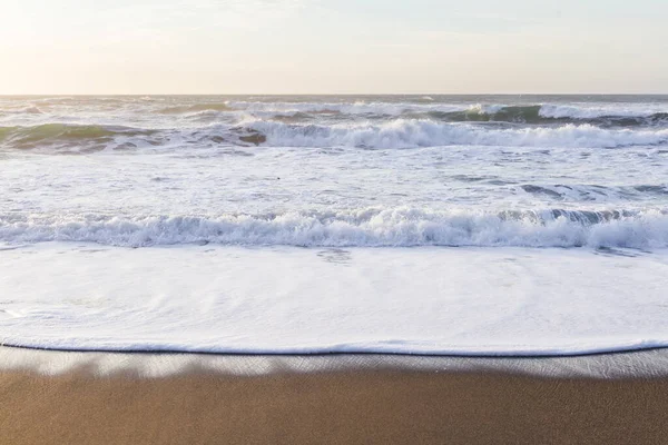 オレゴン州の海岸で晴れた日の午後に海岸を出入りする穏やかな波 — ストック写真