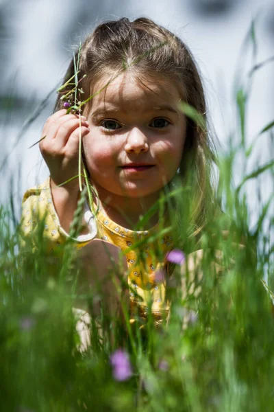 幸せな4歳の少女が緑の草の上に座り — ストック写真