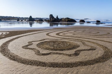 Bandon by the Sea, Oregon / USA - 13 Mart 2020: Face Rock State Park plajında Circles in the Sand ekibi tarafından oluşturulan ayrıntılı sanat çalışması