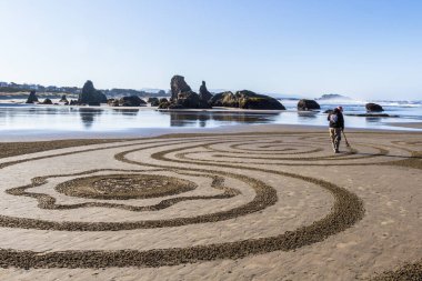 Bandon by the Sea, Oregon / USA - 13 Mart 2020: Denny Dike ve Circles in the Sand ekibi tarafından Face Rock State Park plajında oluşturulan ayrıntılı sanat çalışması