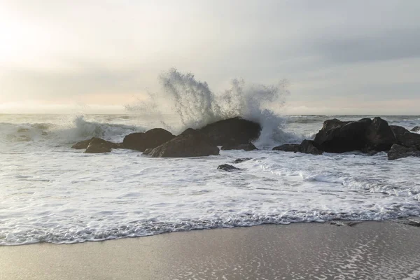 オレゴン州ネシカビーチのロッキー海岸線午後遅く 太陽が地平線に接近し 波が岩に衝突する — ストック写真