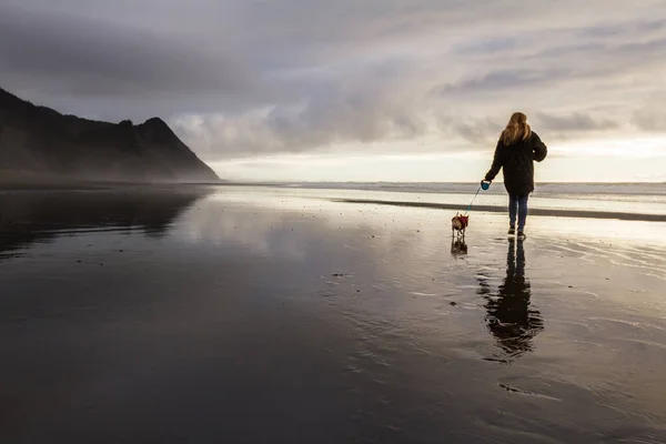 オレゴン州南部海岸のチワワをぬれた砂の上を歩いていた女性が反射してセバスチャン岬までの距離を — ストック写真