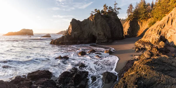 秘密のビーチオレゴン州の美しい夕日岩の上に柔らかい暖かい輝きとこのビーチをとても認識可能にする島の上に常緑樹 — ストック写真