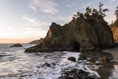 Güney Oregon sahilinde sakin bir sahil. Gizli plaj olarak bilinir. Güzel güneşli bir günde, üzerinde yeşil ağaçlar olan güzel İssletler.