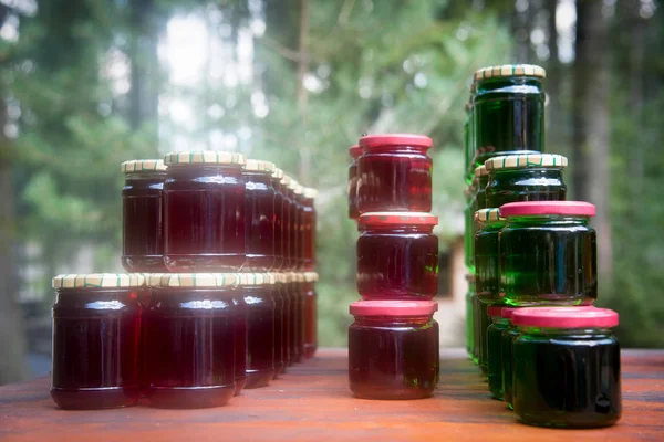 Vários jarros de engarrafamento de fruto na mesa de madeira  . — Fotografia de Stock