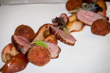 Kırmızı şarap, yeşillik ve patates püresi topları bir armut ile hizmet ördek fileto komposto.