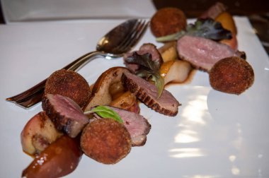 Kırmızı şarap, yeşillik ve patates püresi topları bir armut ile hizmet ördek fileto komposto.