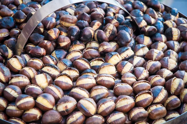 Castanhas assadas em uma frigideira por um vendedor ambulante  . — Fotografia de Stock