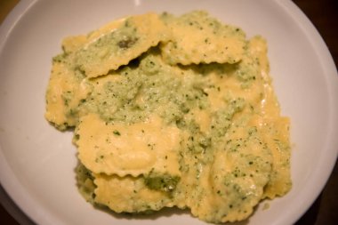 Beyaz bir plaka üzerinde dört peynir ile mantı .