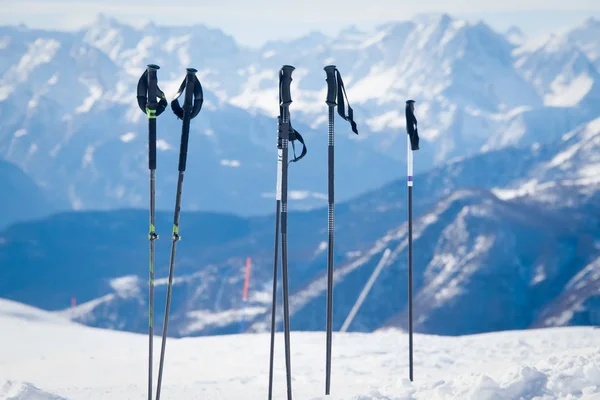 Bastones de esquí en el fondo de un invierno nevado en las montañas  . — Foto de Stock