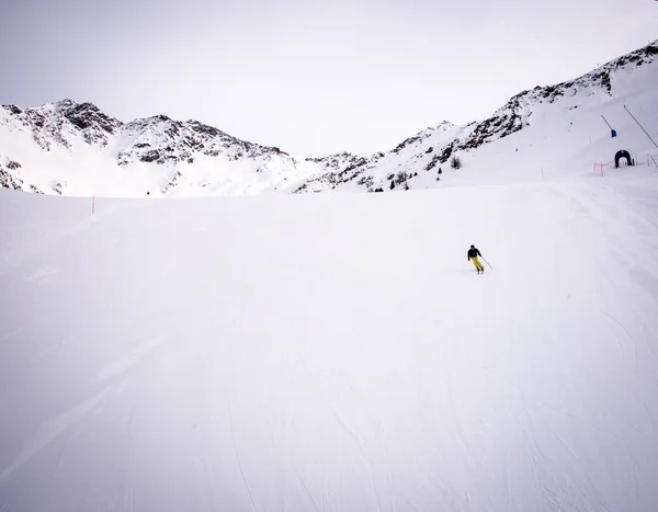 Lone skier  on snowy slope in the italian Alps, with bright sunny day of winter season.   Aosta Valley,  Italy . — Stock Photo, Image