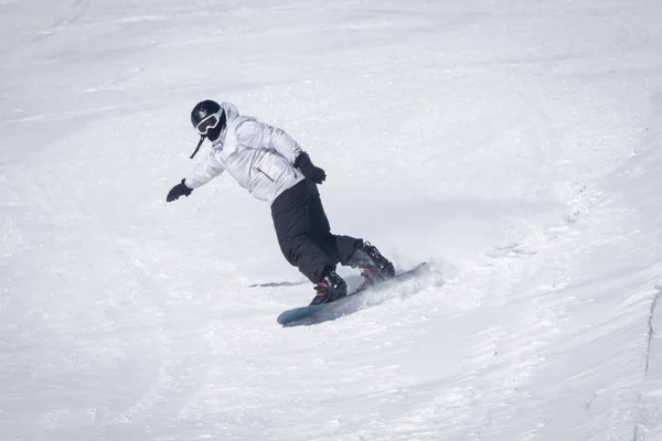 Young guy snowboarder is riding with snowboard from powder snow hill . — Stock Photo, Image