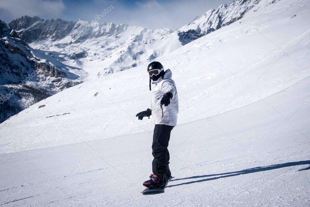 Young guy snowboarder having fun in the winter ski resort .