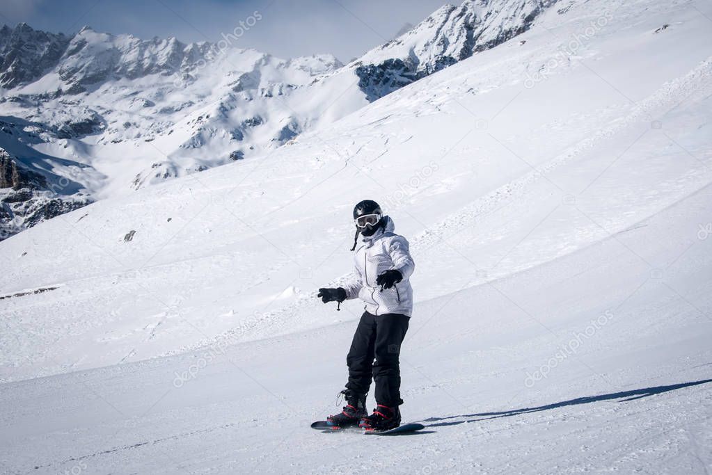 Young guy snowboarder having fun in the winter ski resort .