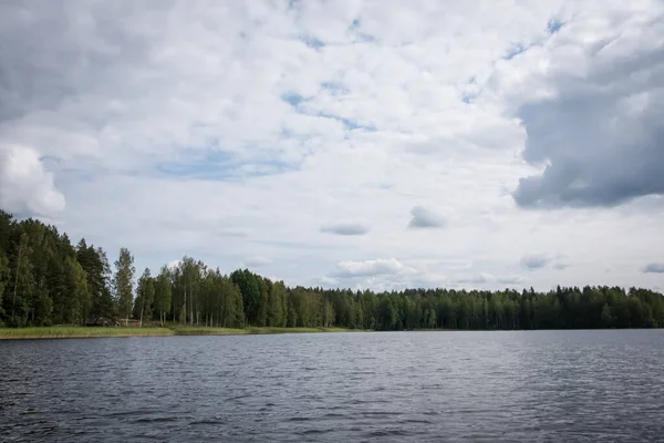 Sommarvy över sjön Hallanlahti med reflektion av moln på vattenytan. Finland . — Stockfoto