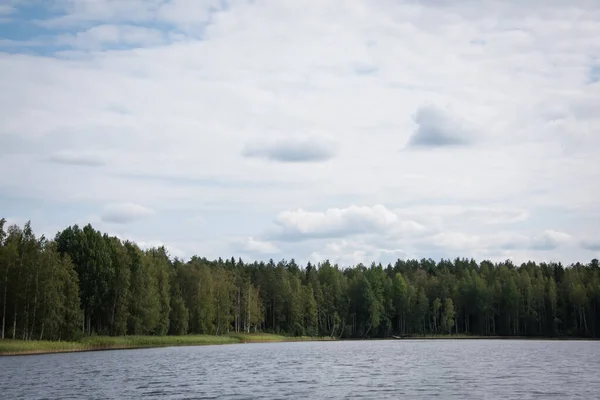Letní výhled na jezero Hallanlahti s odrazem mraků na hladině vody. Finsko . — Stock fotografie