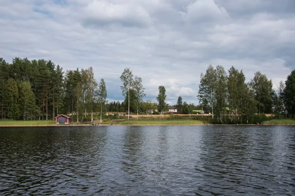 Letní výhled na jezero Hallanlahti s odrazem mraků na hladině vody. Finsko . — Stock fotografie