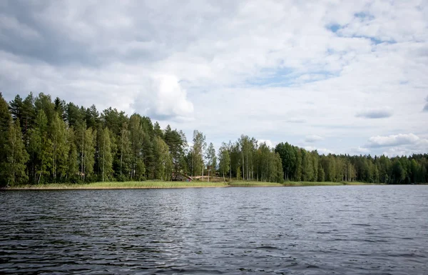 Letní výhled na jezero Hallanlahti s odrazem mraků na hladině vody. Finsko . — Stock fotografie