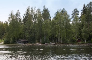 Hallanlahti Gölü yaz manzarası bulutların su üzerindeki yansımasıyla .