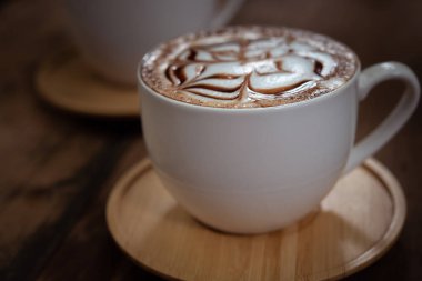 İki bardak kahve güzel latte sanat siyah rustik zemin üzerine. Ahşap bir masa üzerinde kahve