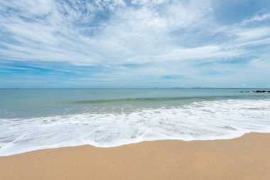 Yumuşak dalgalar üzerinde kum plaj. Beyaz kabarcıklar sahilde okyanus dalgaları seashore tarafından yaratılmıştır. Akış dalga ile tropikal plaj.