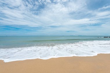 Yumuşak dalgalar üzerinde kum plaj. Beyaz kabarcıklar sahilde okyanus dalgaları seashore tarafından yaratılmıştır. Akış dalga ile tropikal plaj.