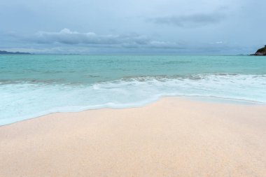 Yumuşak dalgalar üzerinde kum plaj. Beyaz kabarcıklar sahilde okyanus dalgaları seashore tarafından yaratılmıştır. Akış dalga ile tropikal plaj.