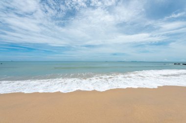 Yumuşak dalgalar üzerinde kum plaj. Beyaz kabarcıklar sahilde okyanus dalgaları seashore tarafından yaratılmıştır. Akış dalga ile tropikal plaj.