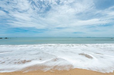 Yumuşak dalgalar üzerinde kum plaj. Beyaz kabarcıklar sahilde okyanus dalgaları seashore tarafından yaratılmıştır. Akış dalga ile tropikal plaj.