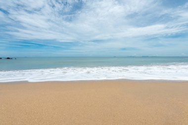 Yumuşak dalgalar üzerinde kum plaj. Beyaz kabarcıklar sahilde okyanus dalgaları seashore tarafından yaratılmıştır. Akış dalga ile tropikal plaj.