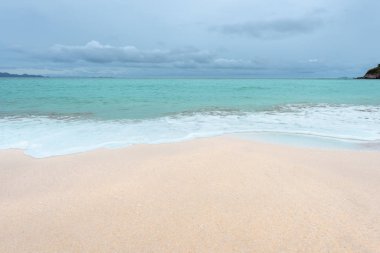 Yumuşak dalgalar üzerinde kum plaj. Beyaz kabarcıklar sahilde okyanus dalgaları seashore tarafından yaratılmıştır. Akış dalga ile tropikal plaj.