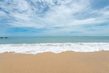 Yumuşak dalgalar üzerinde kum plaj. Beyaz kabarcıklar sahilde okyanus dalgaları seashore tarafından yaratılmıştır. Akış dalga ile tropikal plaj.
