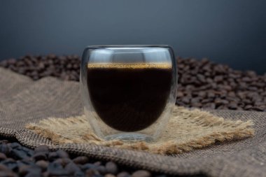 Kahve fincanı ve siyah arka plan üzerine kahve çekirdekleri. bir çift popolu cam siyah kahve. 