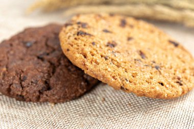 Çikolatalı kurabiye ve karanlık eski ahşap masa üzerinde badem çerezler. 