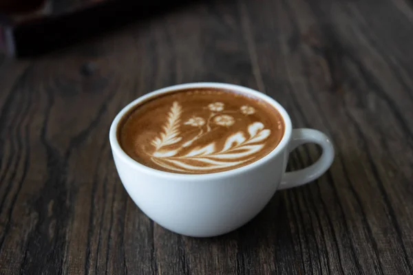 カフェで木製テーブルの上の白いコーヒー カップ カフェラテ アート コーヒー カップ — ストック写真