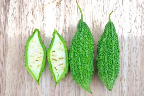 Bitter melon or Bitter gourd with half sliced on wooden background. bitter gourds.