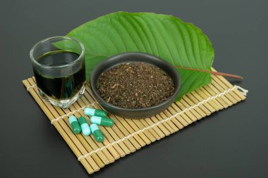 Toz ürün beyaz seramik kase ve su ile Mitragynina speciosa veya Kratom kratom yaprakları özler bırakır. Ek kratom yeşil kapsül. 