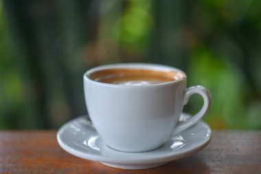 Kahve fincanı. Ahşap arka plan üzerinde beyaz bir fincan kahve 