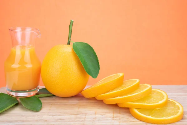 Апельсиновий сік і апельсини з листям — стокове фото