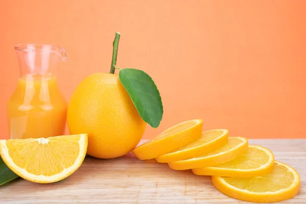 Jugo de naranja y naranjas con hojas — Foto de Stock