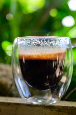 Masada bir fincan espresso. Kokteyl ya da kahve için cam deney şişesi. Bir bardak espresso iç. Beyaz arka planda çift duvarlı sıcak kahve..