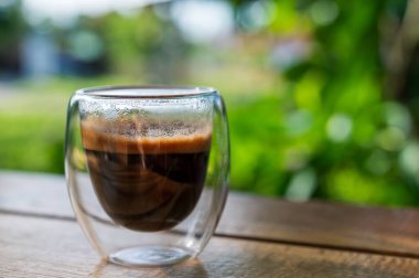 Masada bir fincan espresso. Kokteyl ya da kahve için cam deney şişesi. Bir bardak espresso iç. Beyaz arka planda çift duvarlı sıcak kahve..