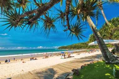 NOOSA, AUSTRALIA, FEB 17 2018: People enjoying summer at Noosa main beach - a famous tourist destination in Queensland, Australia. clipart