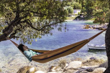 Kim bir tropikal plajda hamakta rahatlatır küçük Asya