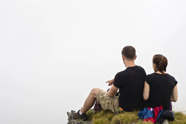 山の上に座るし 景色を若い人たちの美しいカップル — ストック写真