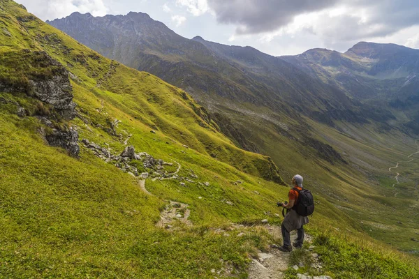 Caucasian man with backpack hiking on a trail in the rocky mountains